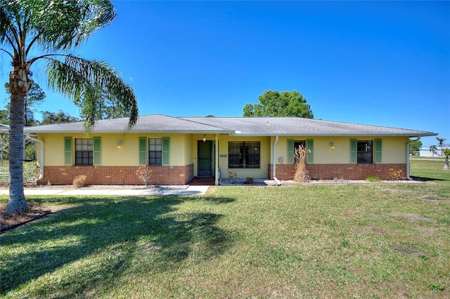 ranch-style home with stucco siding, brick siding, and a front yard