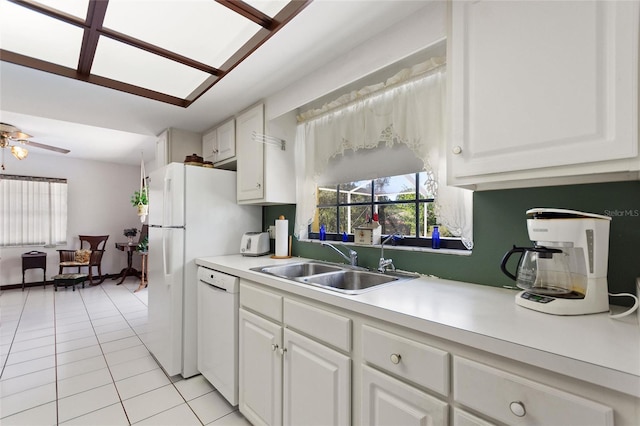 kitchen with light tile patterned floors, white cabinetry, a sink, light countertops, and dishwasher