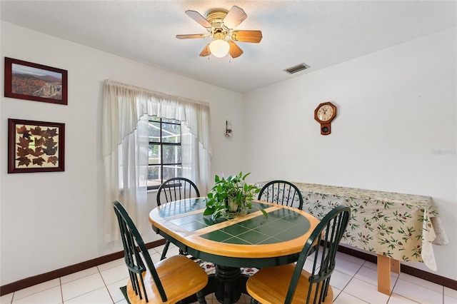 dining room with visible vents, a textured ceiling, baseboards, and ceiling fan