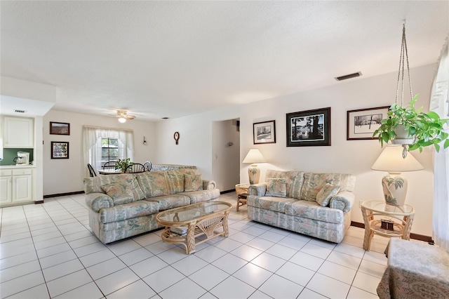 living room featuring light tile patterned floors, visible vents, and baseboards