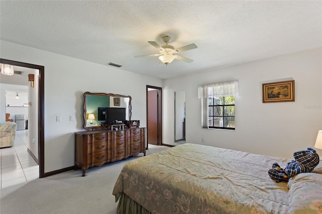 bedroom with light carpet, visible vents, a textured ceiling, and ceiling fan