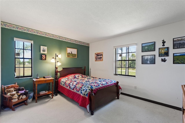 bedroom with baseboards, multiple windows, a textured ceiling, and carpet floors