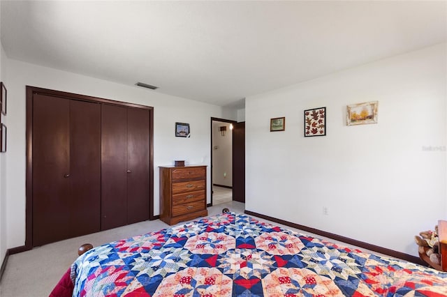 bedroom with a closet, visible vents, light colored carpet, and baseboards