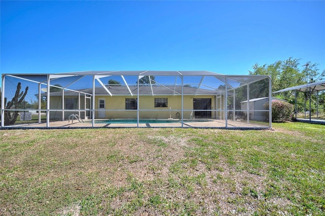 rear view of property featuring glass enclosure, an outdoor pool, a yard, and a patio