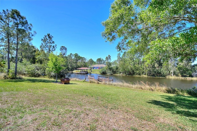 view of yard featuring a dock and a water view