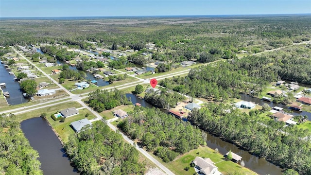 bird's eye view with a residential view, a wooded view, and a water view