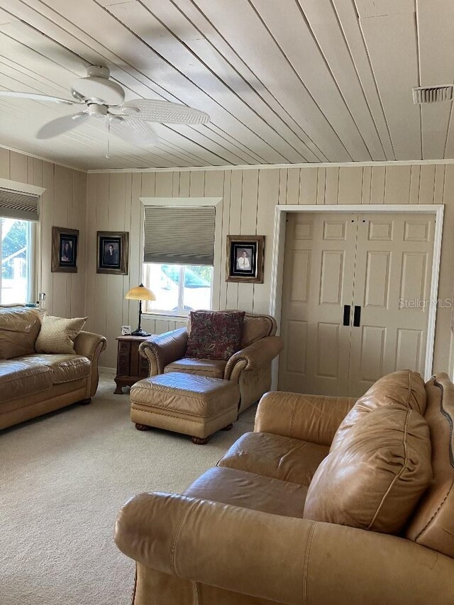 carpeted living area with plenty of natural light, visible vents, wood ceiling, and a ceiling fan