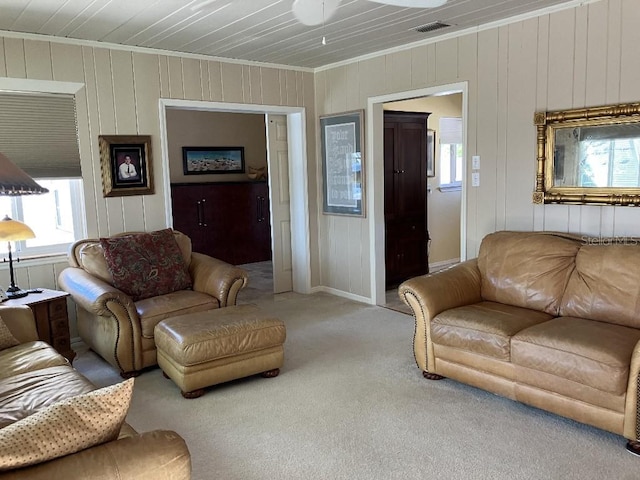 living area with visible vents, carpet floors, and ornamental molding