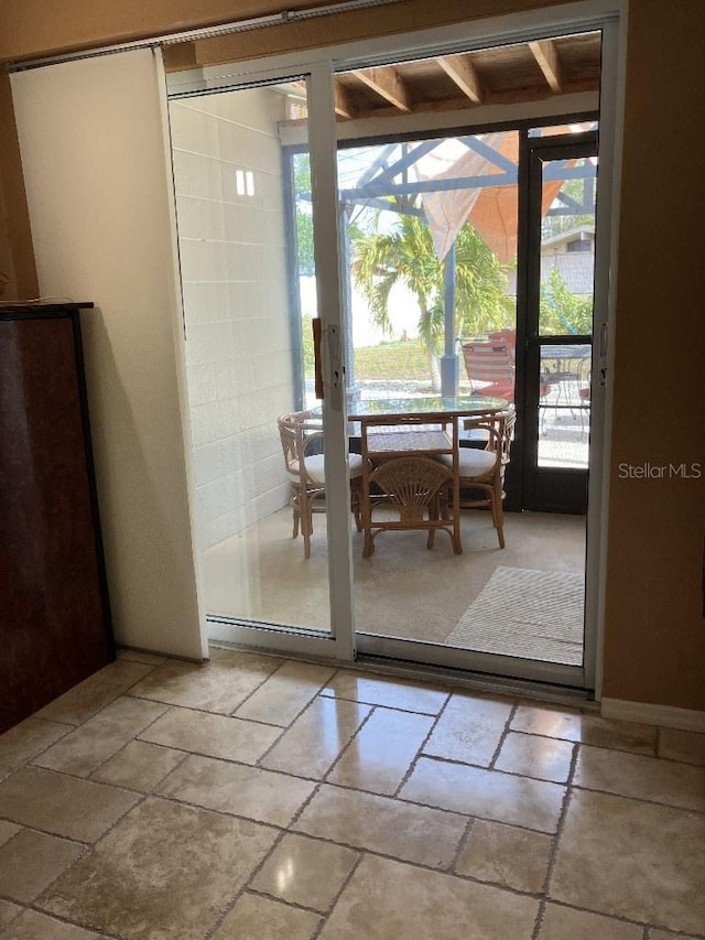 doorway to outside with plenty of natural light and stone tile flooring