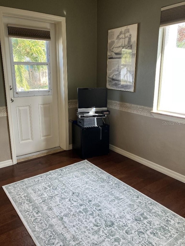 interior space featuring dark wood-type flooring and baseboards