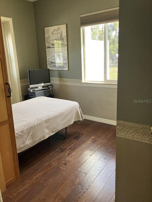 bedroom with baseboards and hardwood / wood-style flooring