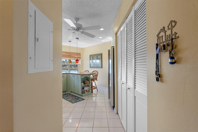 corridor featuring baseboards, electric panel, recessed lighting, light tile patterned flooring, and a textured ceiling