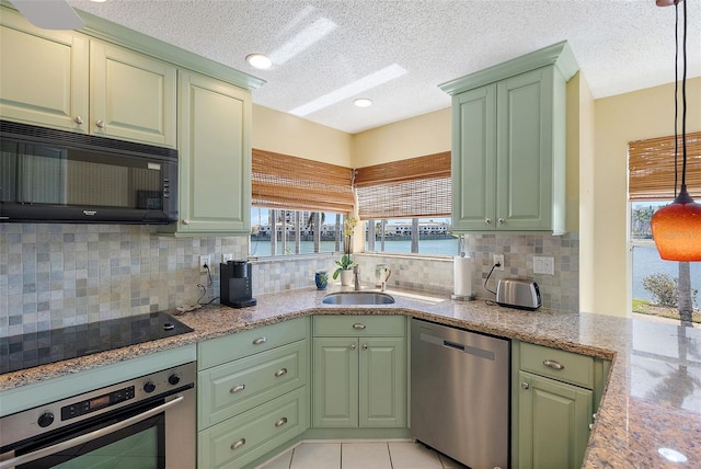 kitchen with a sink, black appliances, and green cabinetry