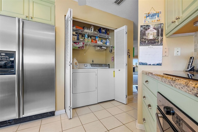 laundry area with light tile patterned flooring, laundry area, and independent washer and dryer