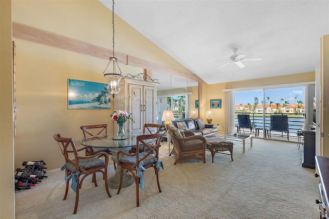 carpeted dining space featuring high vaulted ceiling and a ceiling fan