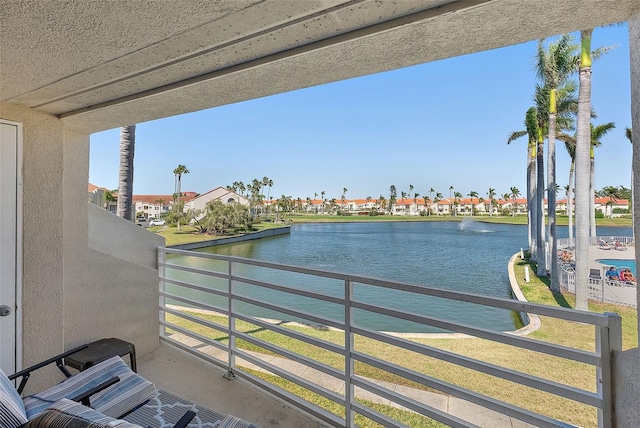 balcony with a residential view and a water view