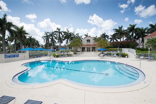 view of swimming pool with a patio and fence