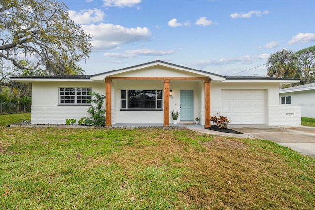 single story home featuring brick siding, concrete driveway, a garage, and a front yard