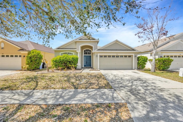 view of front of home with an attached garage, driveway, and stucco siding