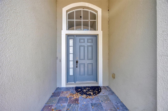 view of exterior entry with stucco siding