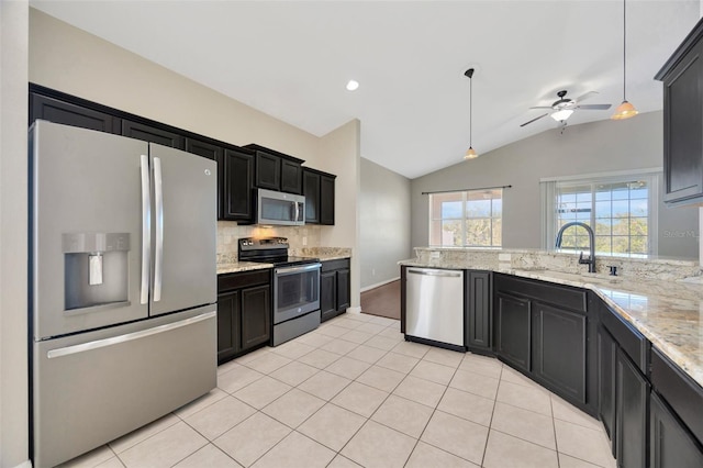 kitchen with a sink, ceiling fan, light tile patterned flooring, stainless steel appliances, and dark cabinets