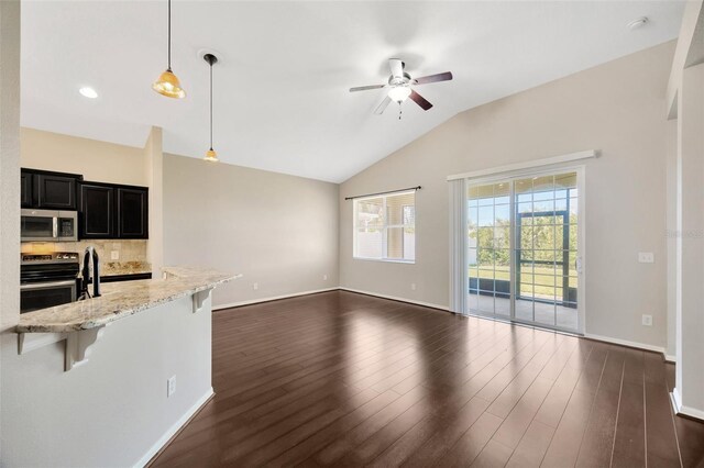 unfurnished living room with vaulted ceiling, a ceiling fan, dark wood-style flooring, and baseboards