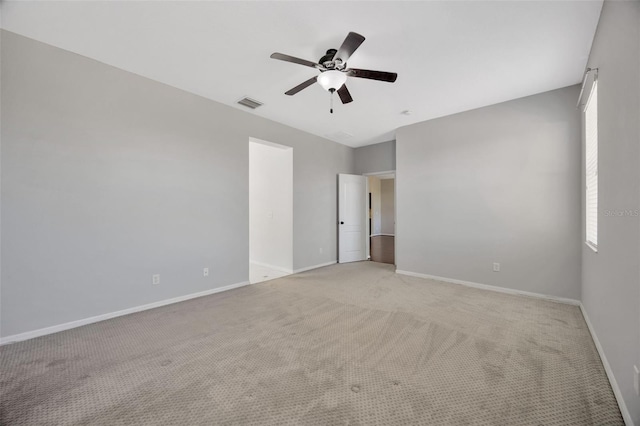 empty room with visible vents, baseboards, light colored carpet, and ceiling fan