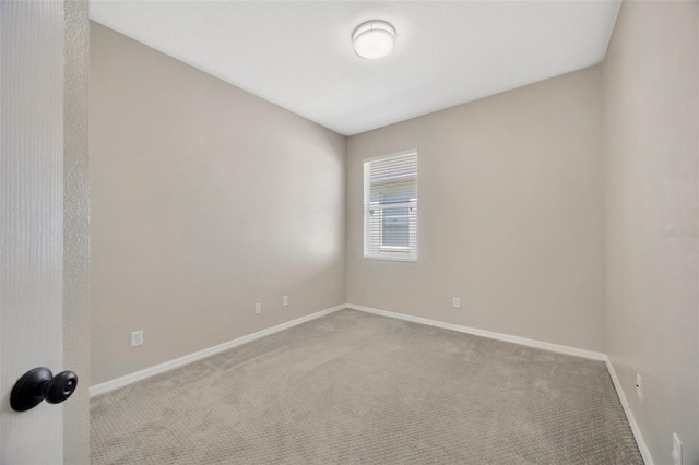 empty room featuring baseboards and carpet