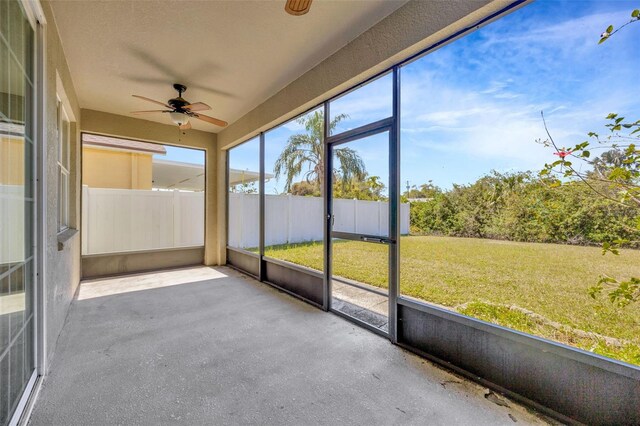 unfurnished sunroom with a ceiling fan