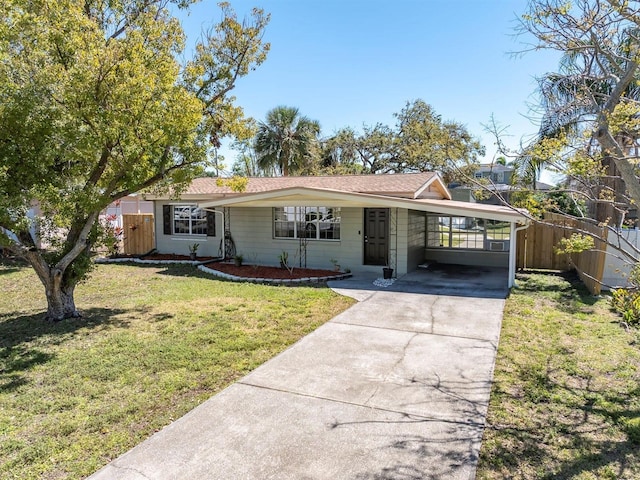 ranch-style house with a carport, driveway, a front yard, and fence