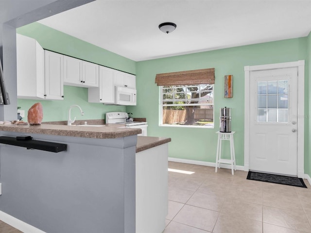 kitchen with white appliances, baseboards, a peninsula, light tile patterned flooring, and white cabinetry