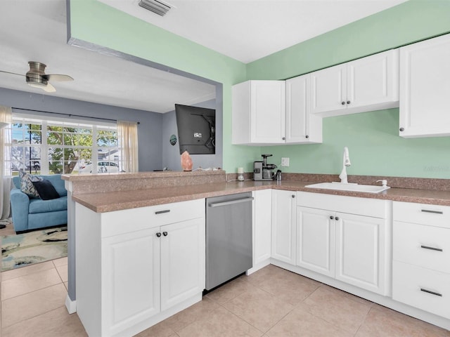 kitchen featuring dishwasher, a peninsula, white cabinets, and a sink