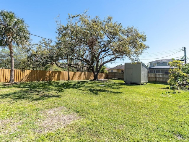 view of yard featuring an outbuilding, a shed, and fence private yard