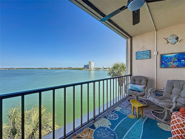 balcony featuring ceiling fan and a water view