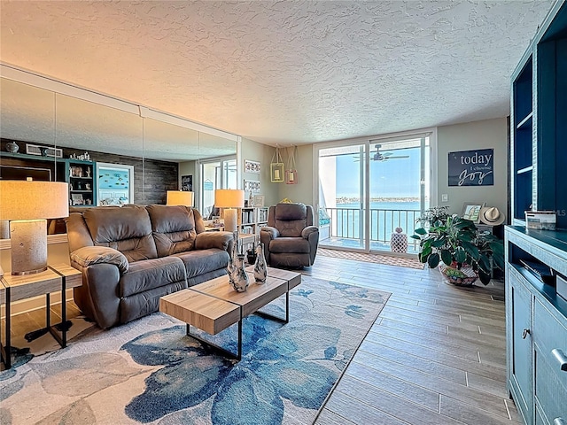 living area with floor to ceiling windows, wood-type flooring, and a textured ceiling