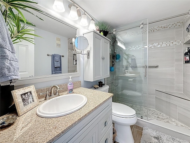 full bath featuring visible vents, vanity, toilet, and a shower stall