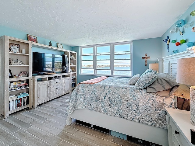 bedroom featuring a textured ceiling and wood finish floors