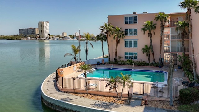 pool featuring a water view, a city view, and fence