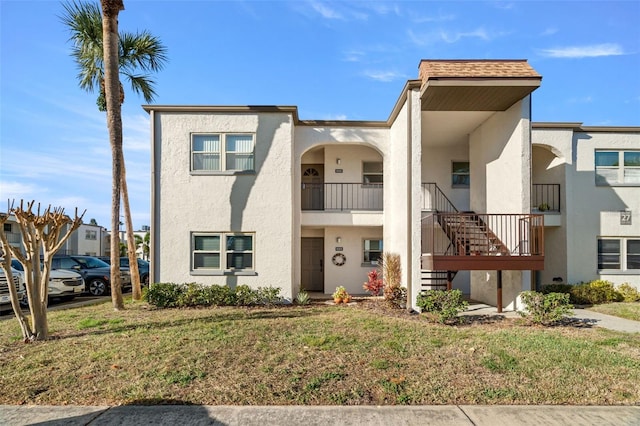 7701 Starkey Rd Unit 526, Seminole, FL 33777 - view of property with stairs, stucco siding, roof with shingles, and a front yard