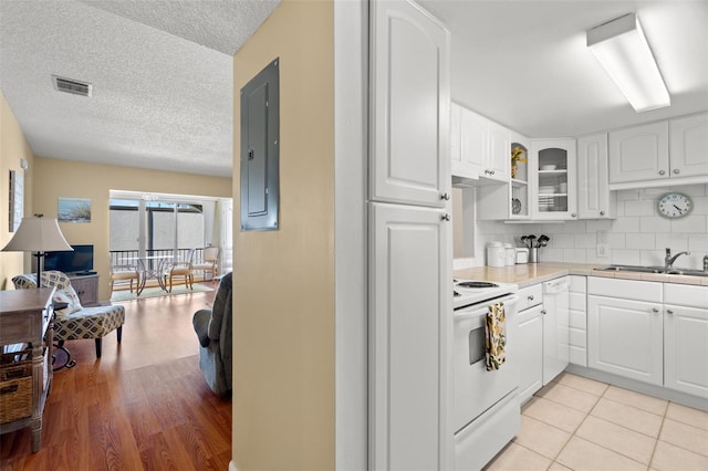 kitchen with tasteful backsplash, visible vents, glass insert cabinets, white appliances, and a sink