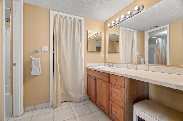 full bathroom featuring tile patterned floors, curtained shower, a textured ceiling, baseboards, and vanity