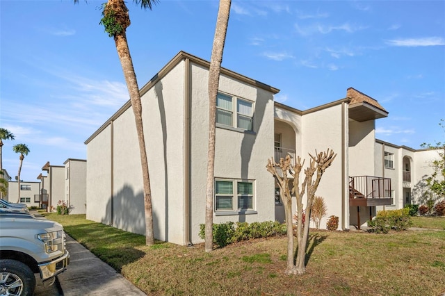 view of side of property with a yard and stucco siding