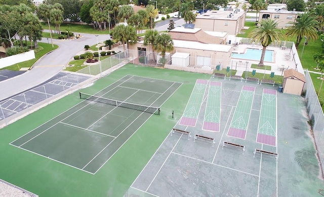 view of tennis court with shuffleboard and fence