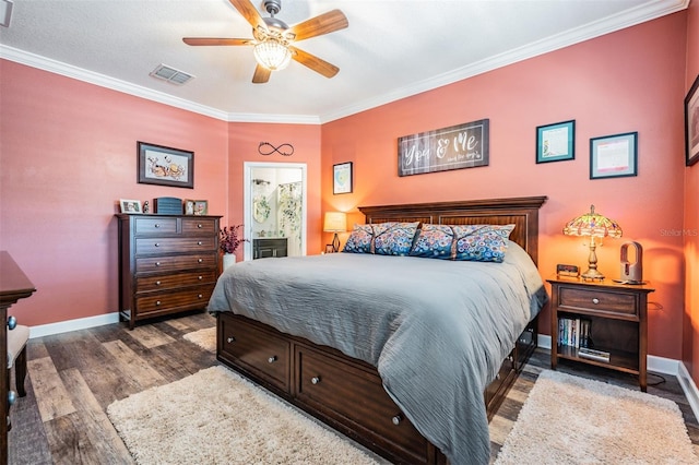 bedroom with visible vents, wood finished floors, crown molding, baseboards, and ceiling fan