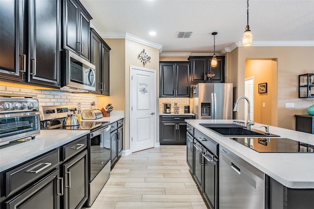 kitchen with visible vents, an island with sink, a sink, appliances with stainless steel finishes, and pendant lighting