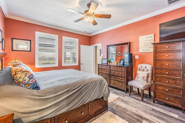 bedroom with crown molding, a ceiling fan, and visible vents