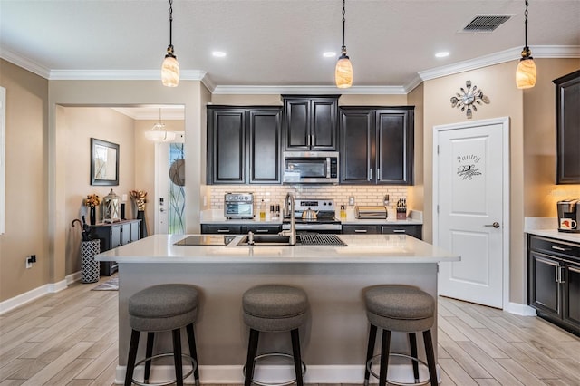 kitchen with stainless steel appliances, visible vents, a breakfast bar area, and light countertops