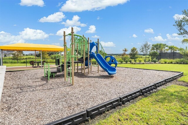 community play area with a yard and fence