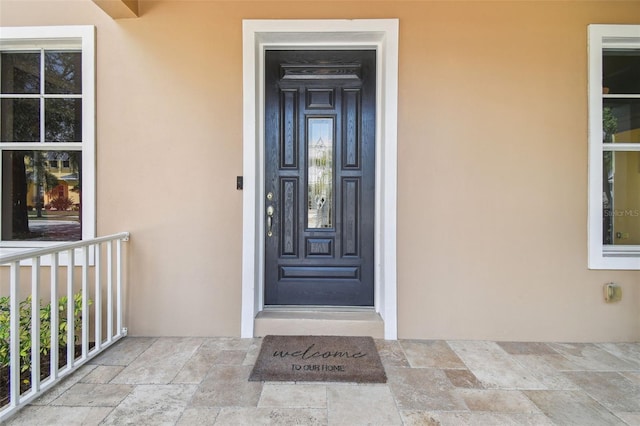doorway to property featuring stucco siding