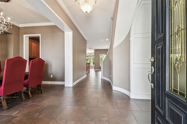 entrance foyer featuring a chandelier, baseboards, and ornamental molding